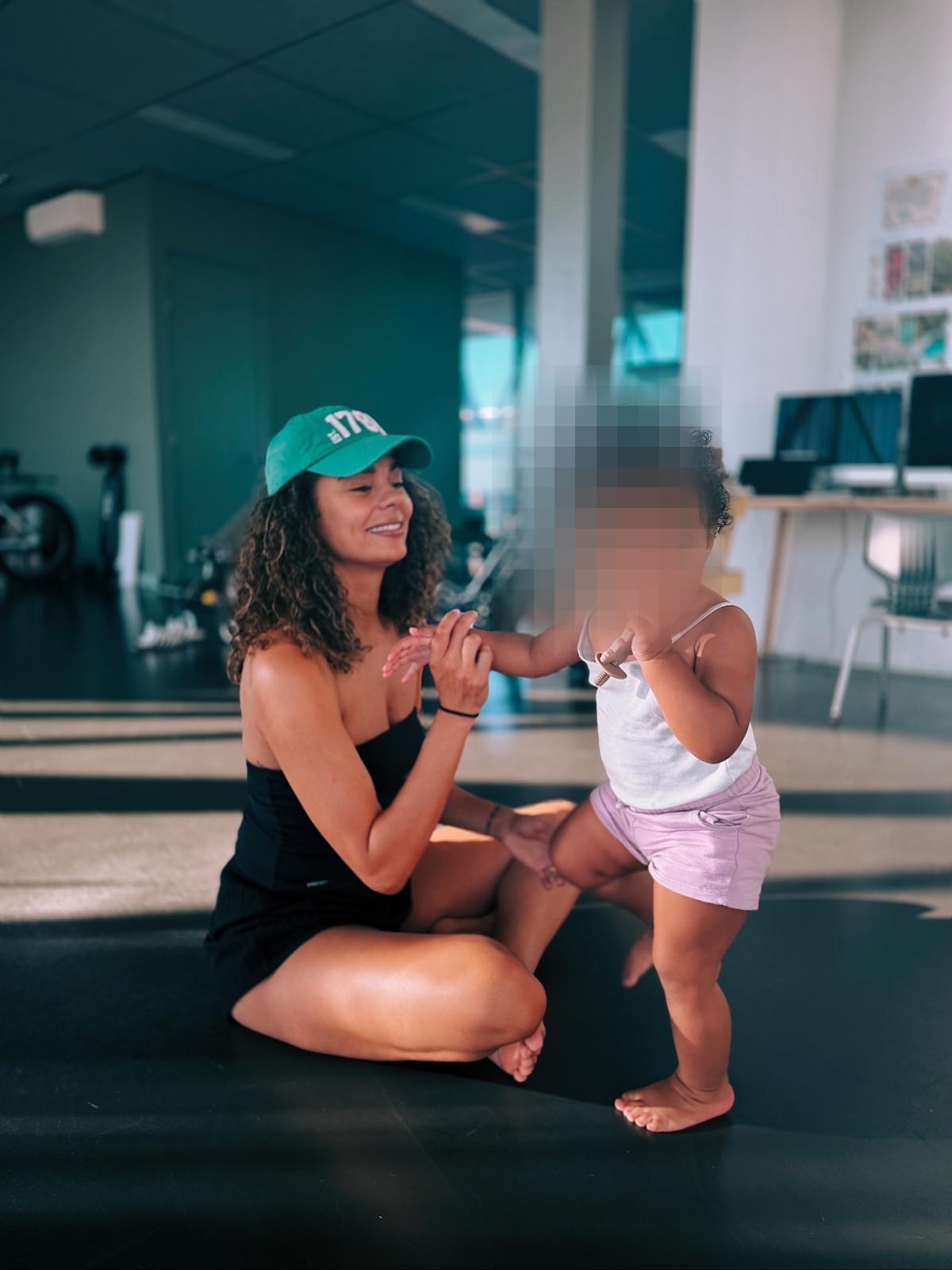 Liz Gray with her daughter in a movement studio, the child's face blurred for privacy.